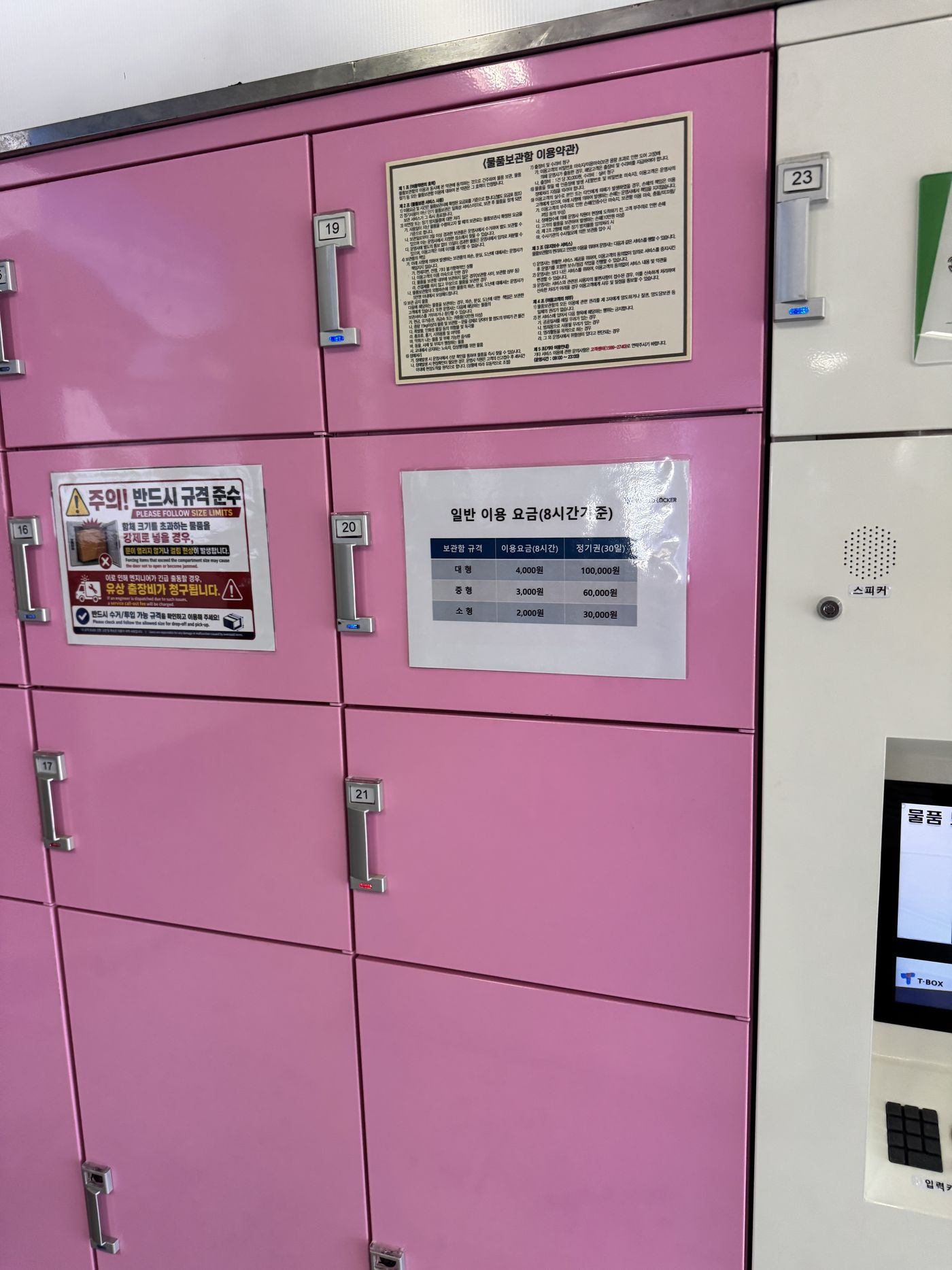 Pink lockers near the drop-off, with the 8-hour price sign